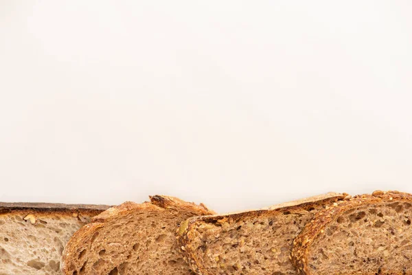 Draufsicht auf frische Vollkornbrotscheiben auf weißem Hintergrund mit Kopierfläche — Stockfoto