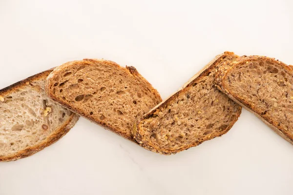 Vista superior de rebanadas de pan de grano entero sobre fondo blanco - foto de stock