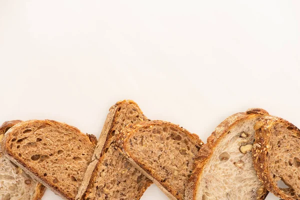 Vue de dessus des tranches de pain de grains entiers sur fond blanc avec espace de copie — Photo de stock