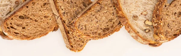 Vista dall'alto di fette di pane integrale su sfondo bianco, colpo panoramico — Foto stock