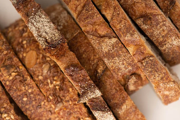 Vue de dessus de tranches de pain de blé entier savoureux avec croûte sur fond blanc — Photo de stock