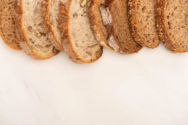 Vista superior de rebanadas frescas de pan integral sobre fondo blanco - foto de stock