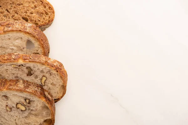 Vista dall'alto di fresche fette di pane integrale su sfondo bianco con spazio copia — Foto stock