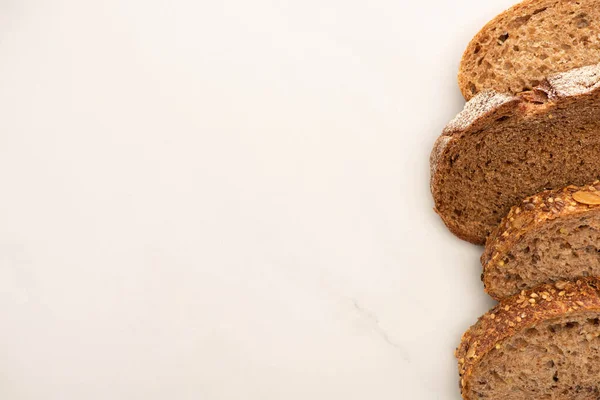 Draufsicht auf frische Vollkornbrotscheiben auf weißem Hintergrund mit Kopierfläche — Stockfoto