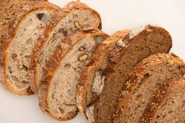 Rodajas de pan de trigo integral fresco sobre fondo blanco - foto de stock