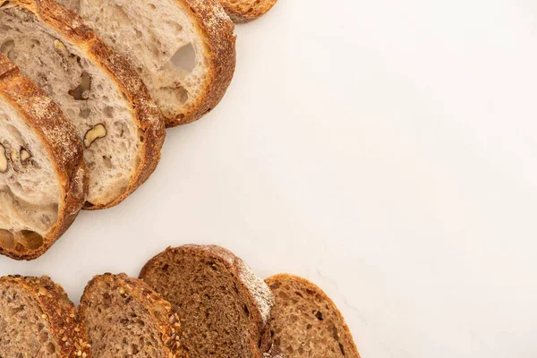 Vue du dessus des tranches de pain de blé entier sur fond blanc avec espace de copie — Photo de stock