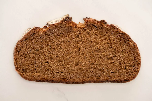 Draufsicht auf frische braune Brotscheibe auf weißem Hintergrund — Stockfoto