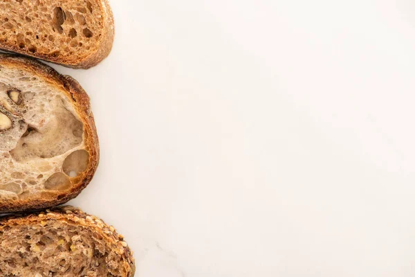 Top view of whole wheat bread slices on white background with copy space — Stock Photo