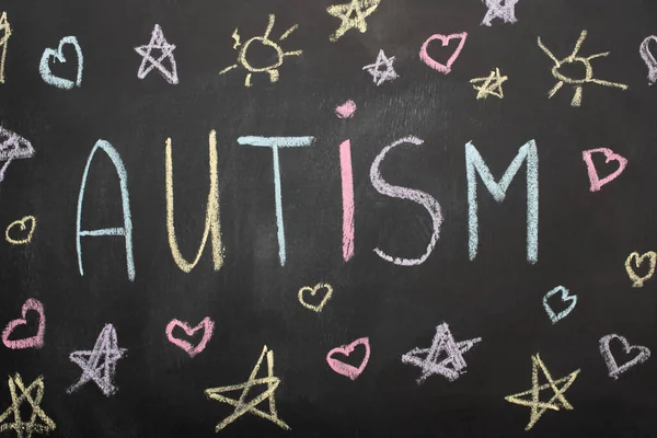 Top view of chalkboard with word autism, hearts and stars drawings — Stock Photo