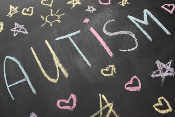 High angle view of chalkboard with autism inscription, hearts, stars and suns — Stock Photo