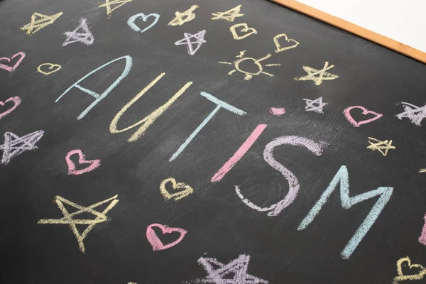 High angle view of chalkboard with word autism, hearts and stars drawings — Stock Photo