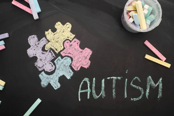 Vue de dessus des craies à bord avec autisme de mot et dessin de puzzle — Photo de stock