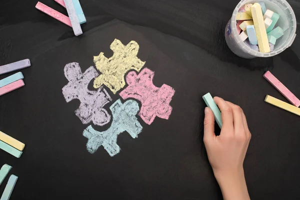 Vista dall'alto della donna che tiene a bordo gesso turchese con disegno puzzle per la Giornata Mondiale della Consapevolezza dell'Autismo — Foto stock