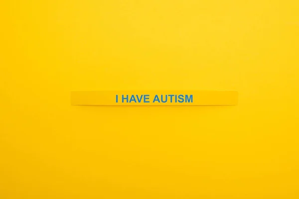 Vista superior da pulseira com eu tenho inscrição autismo isolado no amarelo — Fotografia de Stock