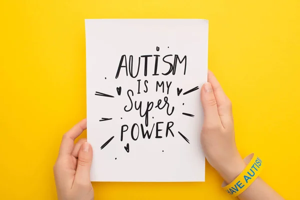 Abgeschnittene Ansicht einer Person, die ein Blatt Papier mit Autismus hält, ist meine Supermachtbeschreibung auf gelb — Stockfoto
