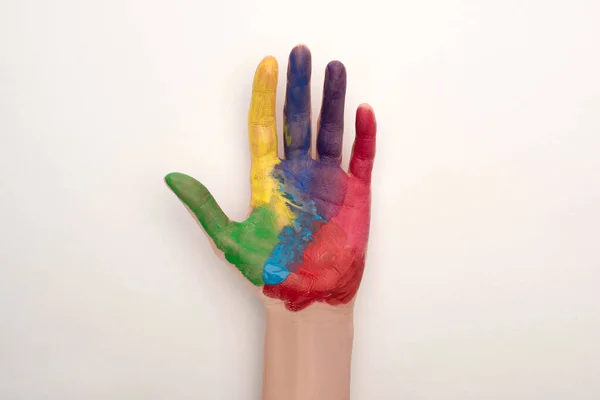 Обрезанный вид женской руки с красочной краской на белом на Всемирный день борьбы с аутизмом — стоковое фото