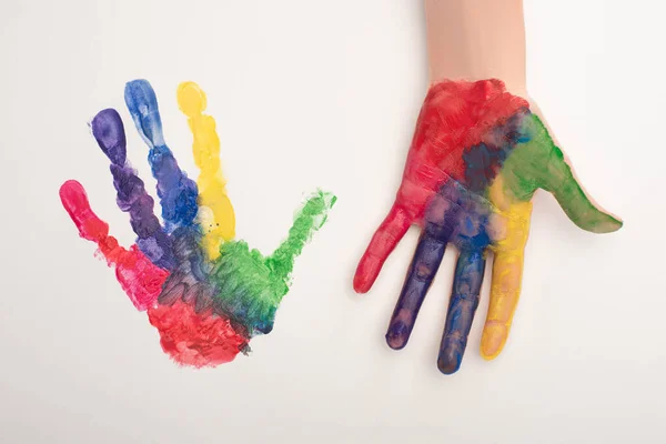 Vista recortada de la mano femenina con colorida huella de mano en blanco para el Día Mundial de la Concienciación sobre el Autismo - foto de stock