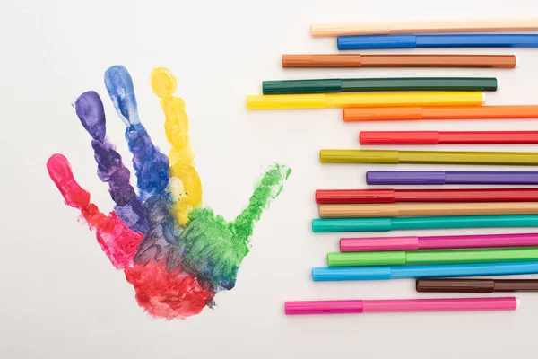 Top view of colorful handprint and markers on white for World Autism Awareness Day — Stock Photo
