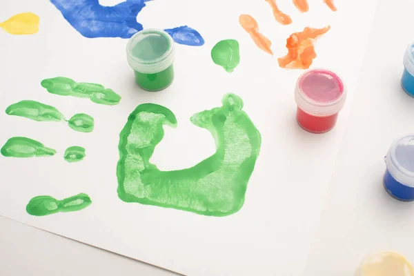 Close up of colorful handprints and paints on white for World Autism Awareness Day — Stock Photo