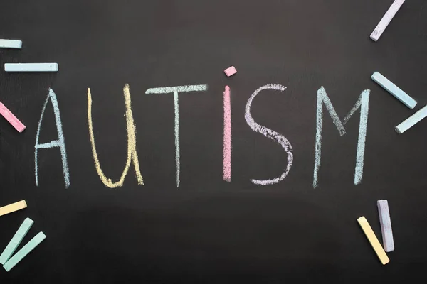 Top view of autism word on blackboard with colorful chalks — Stock Photo