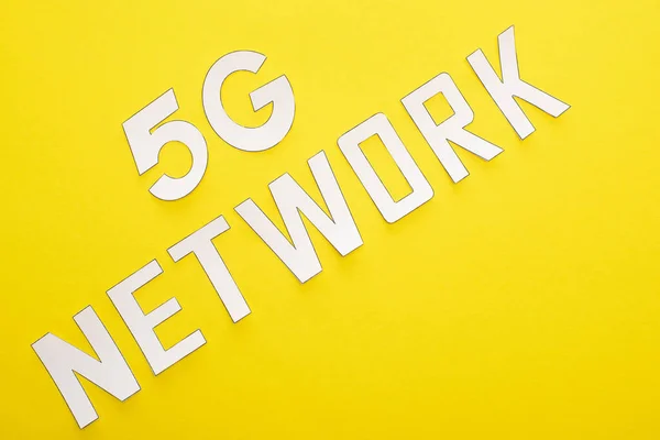 Top view of white 5g network lettering on yellow background — Stock Photo