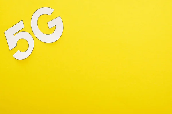 Vue du dessus du lettrage blanc 5g sur fond jaune — Photo de stock