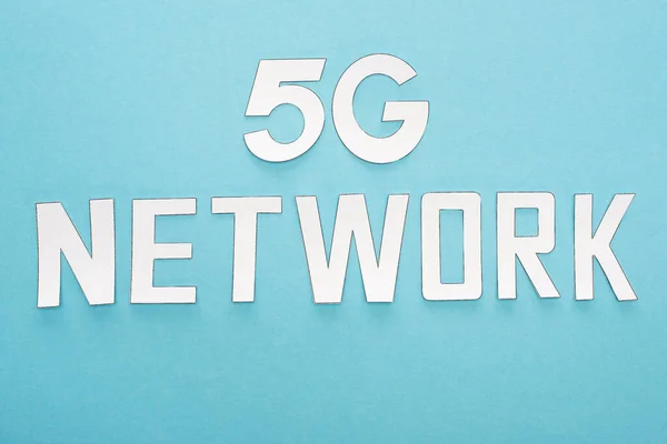 Top view of white 5g network lettering on blue background — Stock Photo