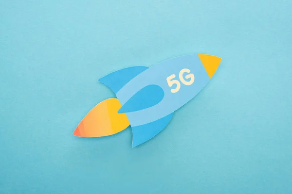 Top view of paper rocket with 5g lettering on blue background — Stock Photo