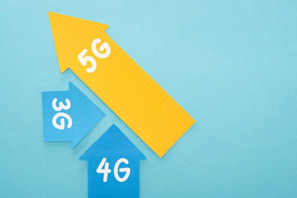 Top view of 3g, 4g and 5g arrows on blue background — Stock Photo