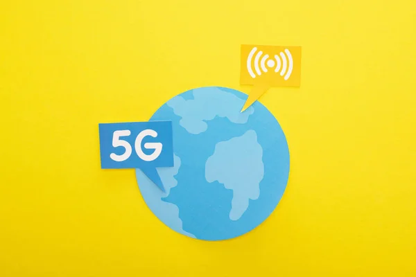 Top view of globe and 5g lettering on yellow background — Stock Photo