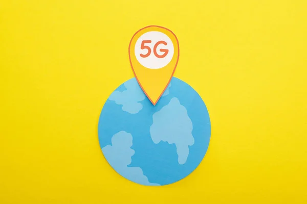 Top view of globe and 5g lettering in location mark on yellow background — Stock Photo