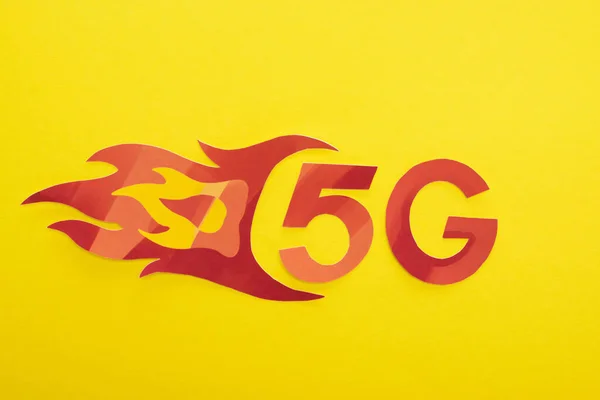 Top view of red 5g with flame lettering on yellow background — Stock Photo