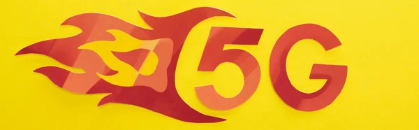 Вид зверху на червоний 5g з написом полум'я на жовтому фоні, панорамний знімок — стокове фото