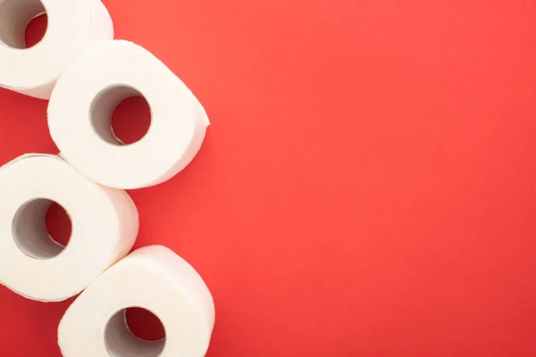 Visão superior de rolos de papel higiênico branco no fundo vermelho com espaço de cópia — Fotografia de Stock