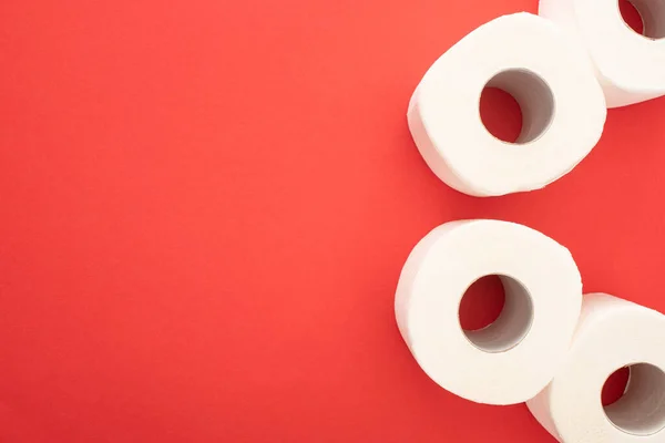 Top view of white toilet paper rolls on red background with copy space — Stock Photo