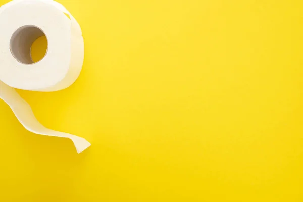 Vue du dessus du rouleau de papier toilette blanc sur fond jaune — Photo de stock