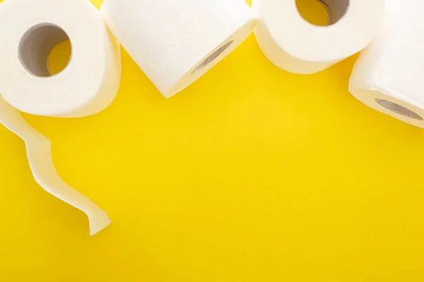 Visão superior de rolos de papel higiênico branco no fundo amarelo com espaço de cópia — Fotografia de Stock