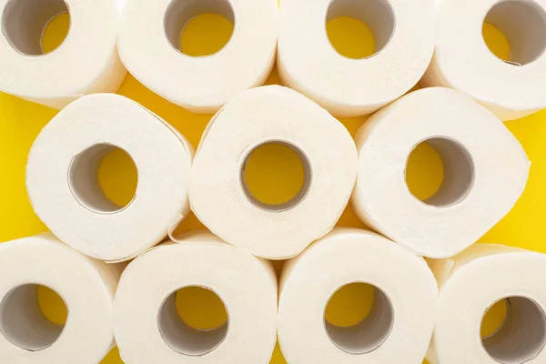 Draufsicht auf weiße Toilettenpapierrollen auf gelbem Hintergrund — Stockfoto