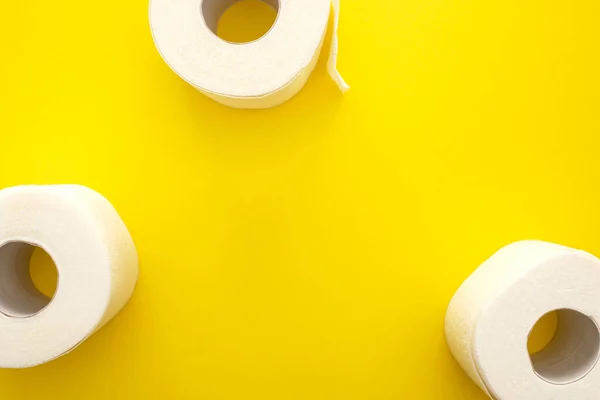 Top view of white toilet paper rolls on yellow background with copy space — Stock Photo