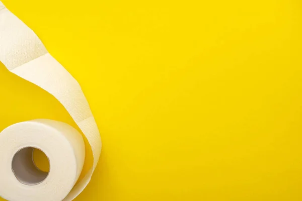 Vista superior do rolo de papel higiênico branco no fundo amarelo com espaço de cópia — Fotografia de Stock