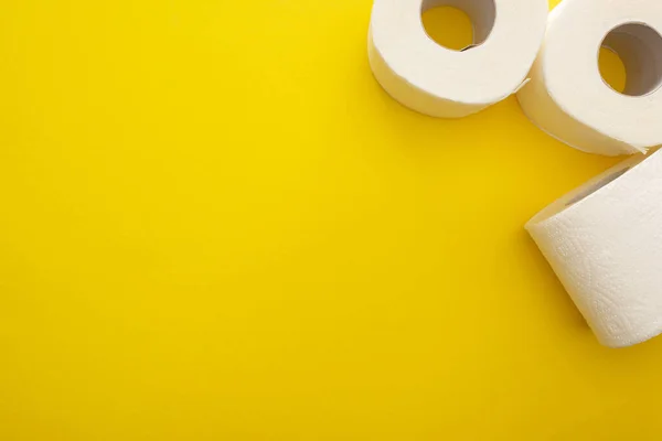 Top view of clean toilet paper rolls on yellow background with copy space — Stock Photo