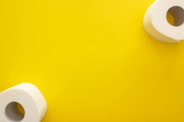 Vista superior de rolos de papel higiênico limpo no fundo amarelo com espaço de cópia — Fotografia de Stock