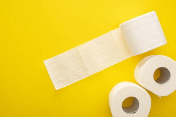 Vue du dessus des rouleaux de papier toilette blanc sur fond jaune — Photo de stock