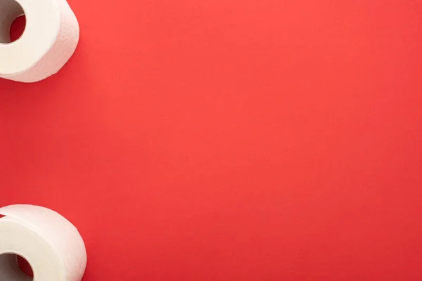 Top view of white toilet paper rolls on red background with copy space — Stock Photo