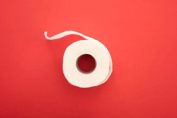 Vista superior do rolo de papel higiênico branco no fundo vermelho — Fotografia de Stock