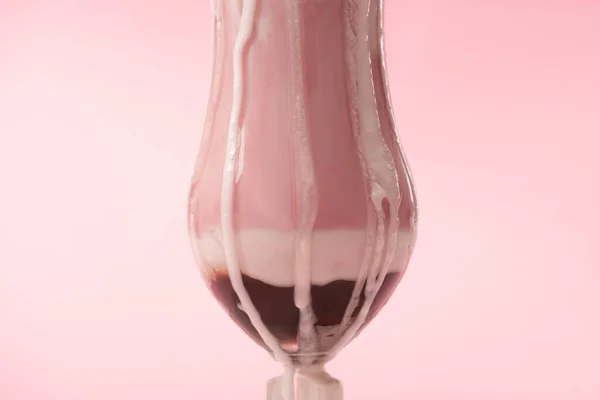 Glas Erdbeer-Milchshake mit Eis tropft auf rosa Hintergrund — Stockfoto