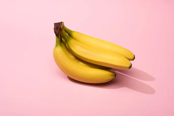 Ripe yellow bananas on pink background — Stock Photo