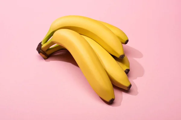 Hochwinkel-Ansicht von reifen gelben Bananen auf rosa Hintergrund — Stockfoto