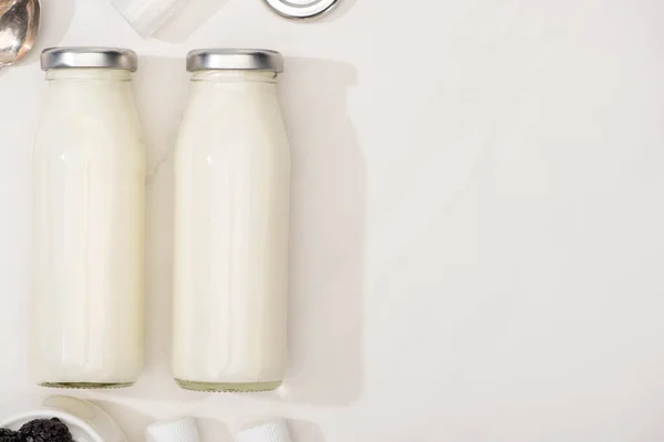 Vista superior de garrafas de iogurte caseiro no fundo branco — Fotografia de Stock