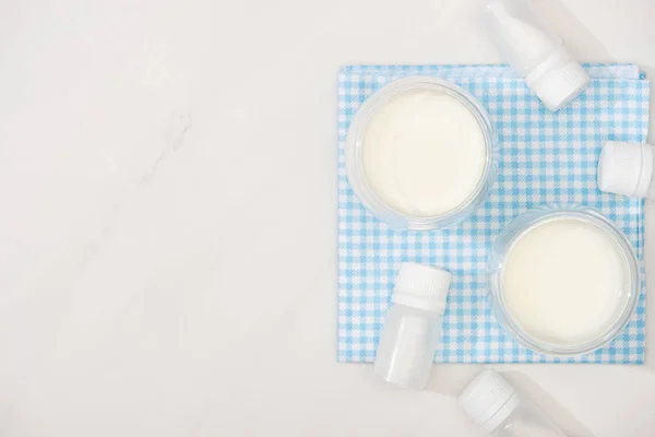 Top view of glasses of homemade yogurt and containers with starter cultures on cloth on white background — Stock Photo